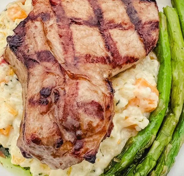 Grilled pork chop over risotto with asparagus